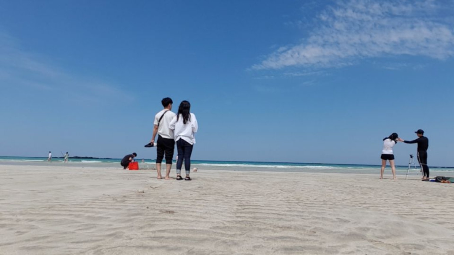 낮 바다를 나란히 바라보는 두 사람의 뒷모습